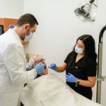 Dr. Zeidan with a female staff during a procedure with an elderly man